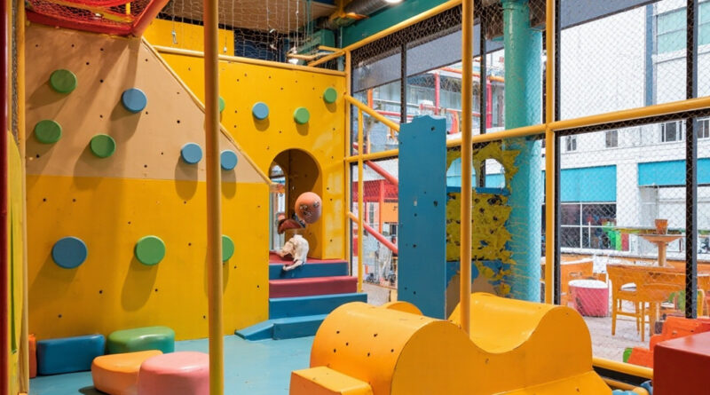 A child experiencing an indoor playground with colorful climbing structures and ball pits in Hong Kong
